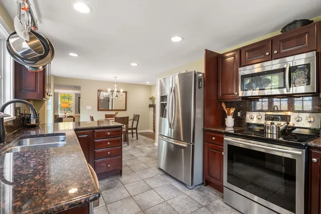 a dining table with chairs and kitchen view
