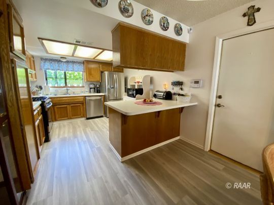 812 Charles Court Ridgecrest, CA 93555 - Photo 19 of 32 a kitchen with a sink a counter top space stainless steel appliances and a window