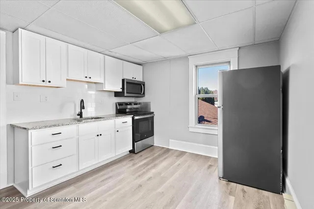 a kitchen with white cabinets and stainless steel appliances