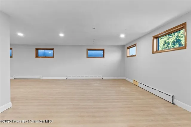 a view of a big room with wooden floor and windows