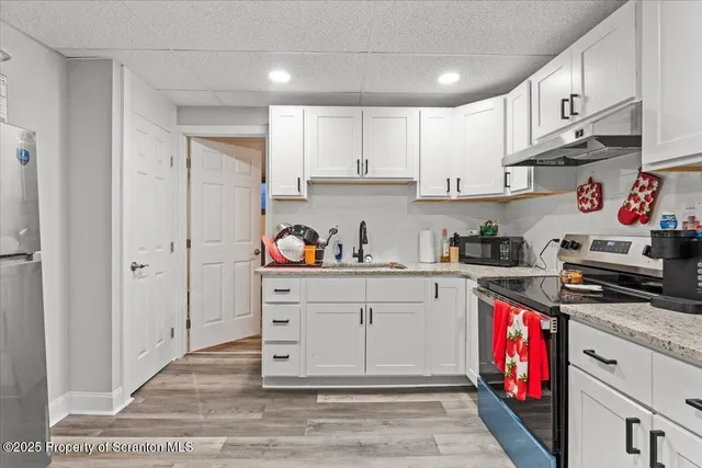a kitchen with stainless steel appliances granite countertop a stove a sink and a refrigerator with cabinets