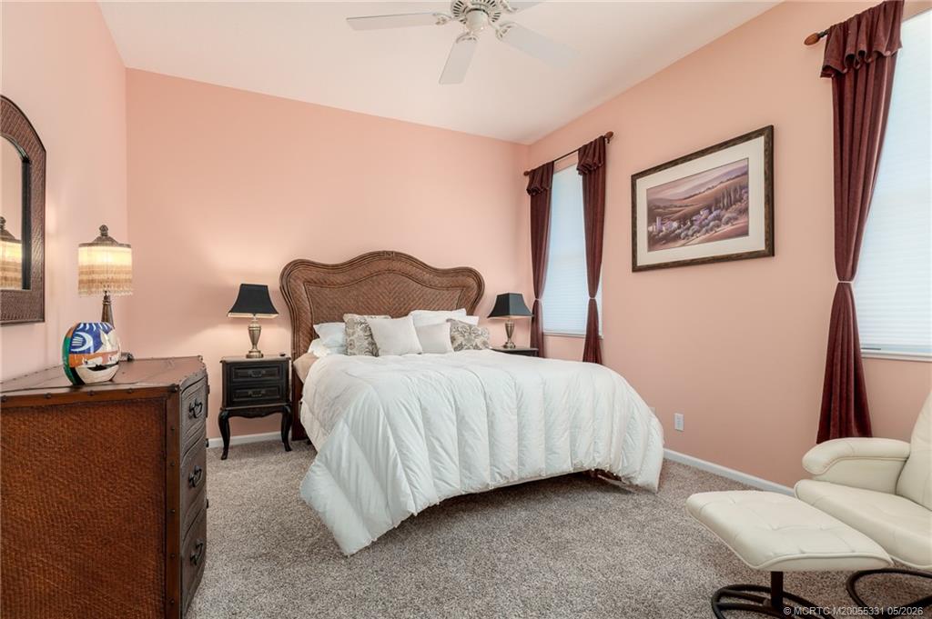 2216 Southeast Stonehaven Road Port St. Lucie, FL 34952 - Photo 21 of 67 a bedroom with a bed and a chandelier