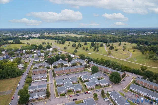 an aerial view of a city with lots of residential buildings ocean and mountain view in back