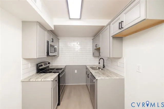 a room with a sink a window and cabinets