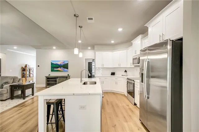 a kitchen with stainless steel appliances a refrigerator sink and microwave