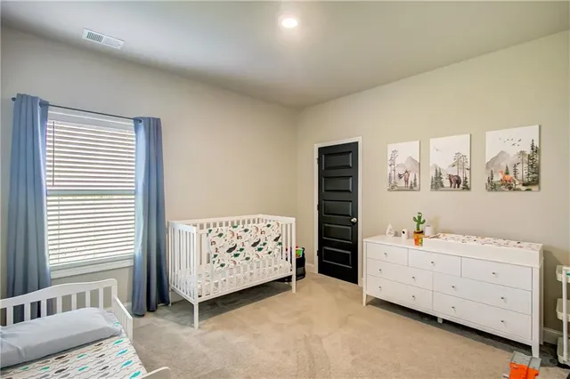 a bedroom with a baby bed dresser and a window