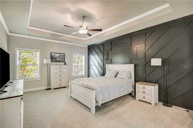 a spacious bedroom with a bed and a flat screen tv