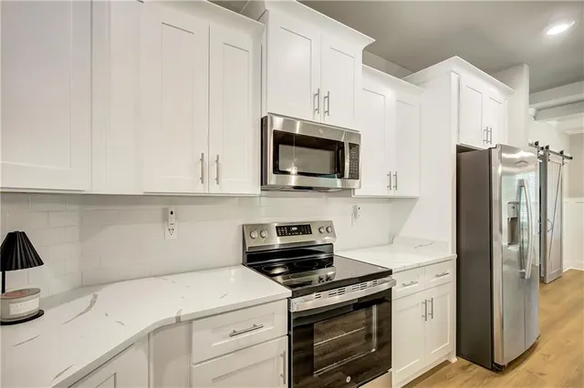 a kitchen with appliances a sink and cabinets