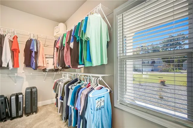 a view of walk in closet with clothes