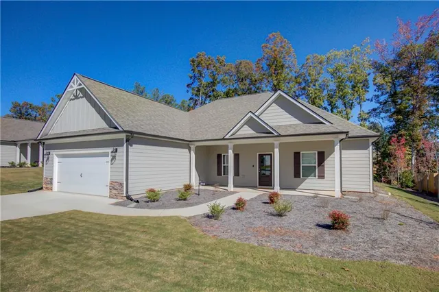 a view of a white house with a outdoor space and potted plants