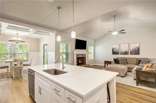 a kitchen with a stove a sink a dining table and chairs with wooden floor