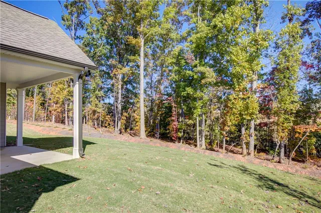 a view of a yard with plants and wooden fence