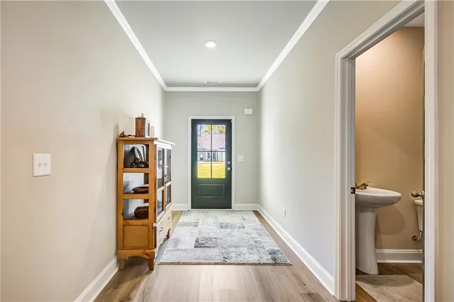 a view of a hallway with wooden floor and bathroom