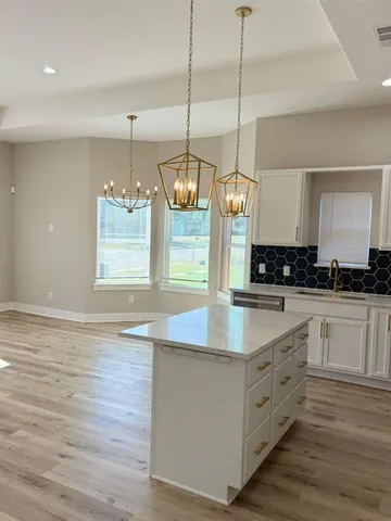 a kitchen with stainless steel appliances granite countertop a sink a stove and a wooden floor