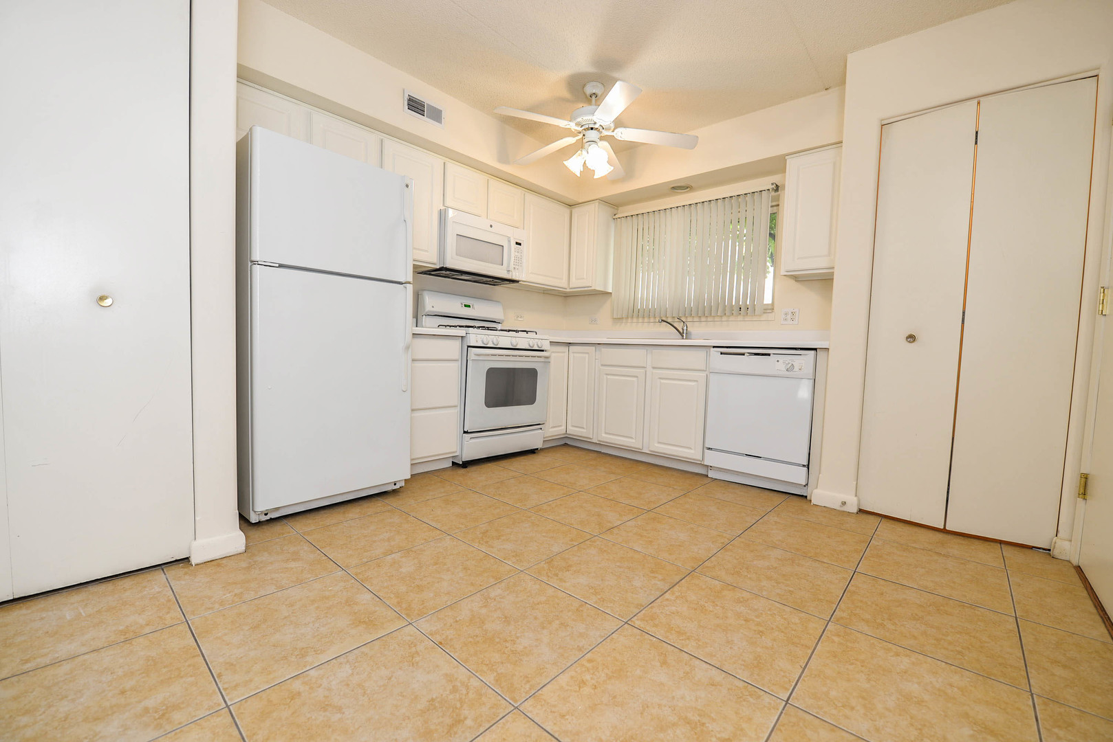 5337 North East River Road, Unit 302 Chicago, IL 60656 - Photo 2 of 22 a kitchen with a stove a refrigerator and white cabinets