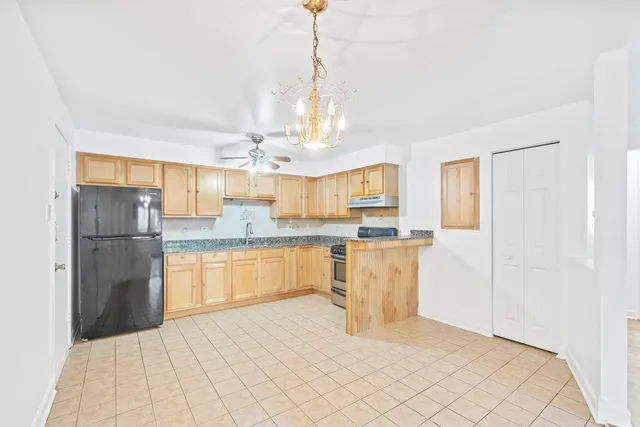 a kitchen with a refrigerator a sink dishwasher with a dining table and chairs