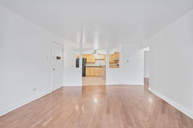 a view of empty room with wooden floor