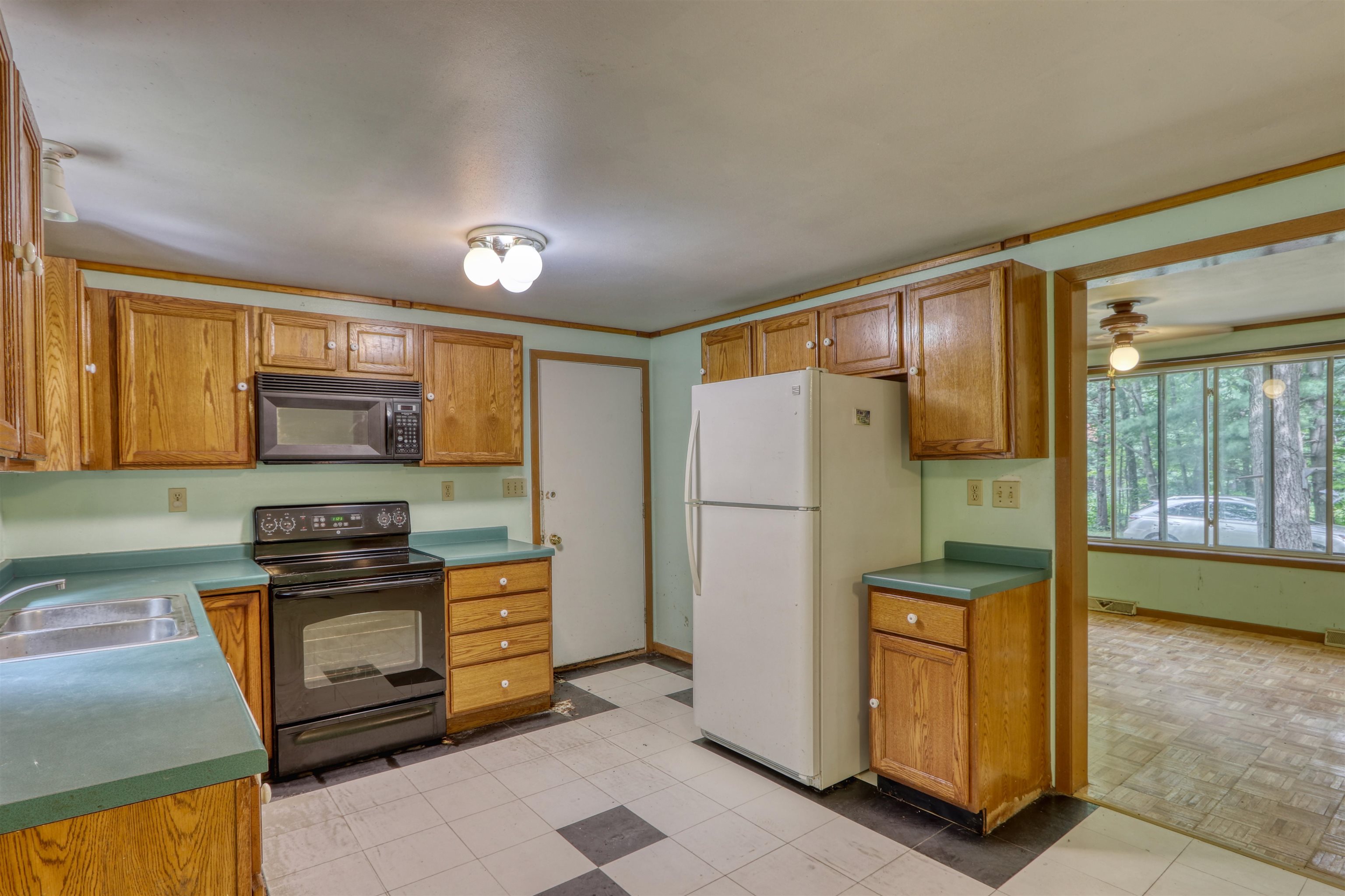 22655 Sunset Acres Lane Grand View, WI 54839 - Photo 11 of 47 Kitchen featuring black appliances, crown molding, brown cabinetry, and ceiling fan