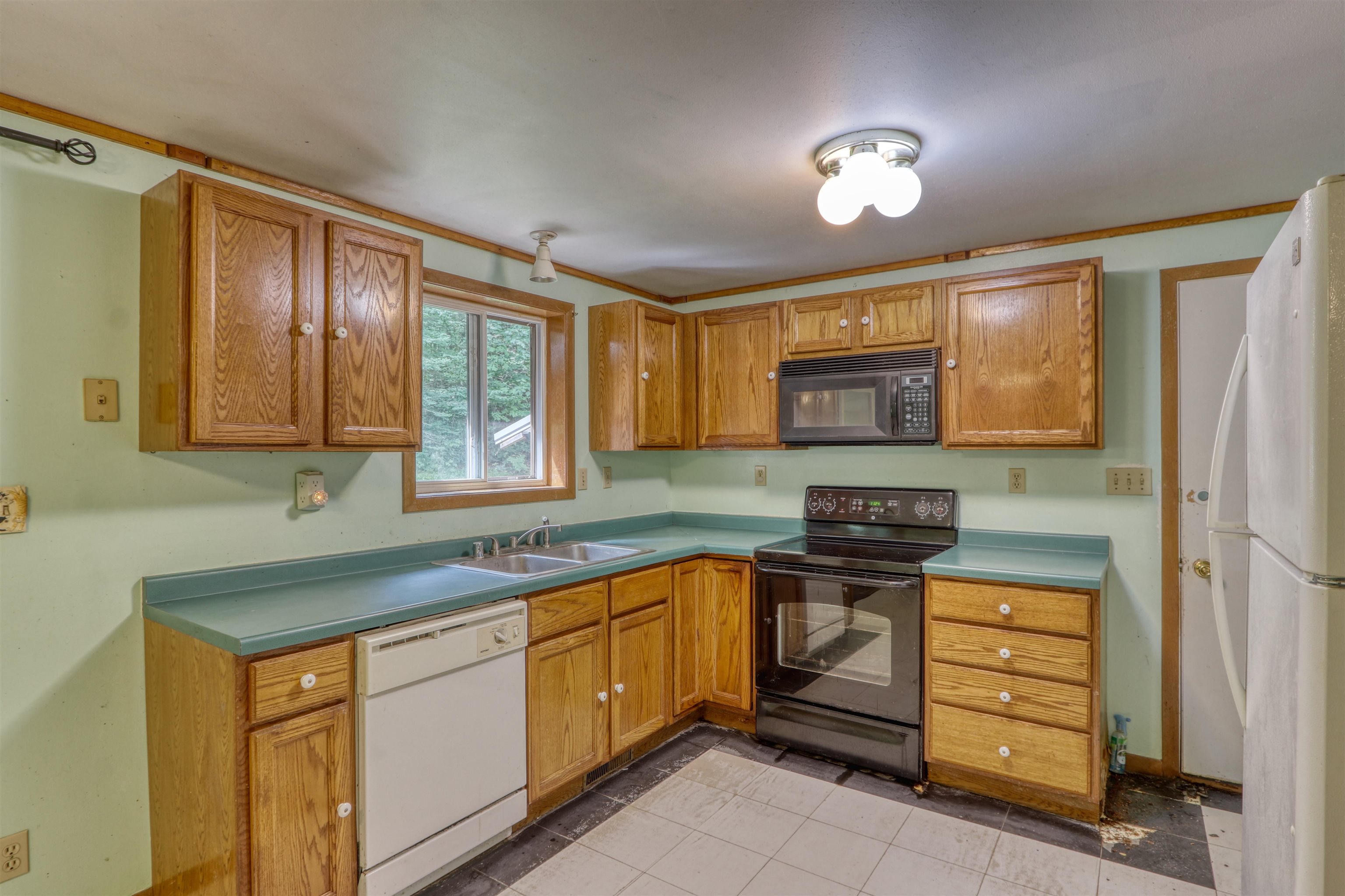 22655 Sunset Acres Lane Grand View, WI 54839 - Photo 12 of 47 Kitchen with black appliances, brown cabinetry, light countertops, and light tile patterned flooring