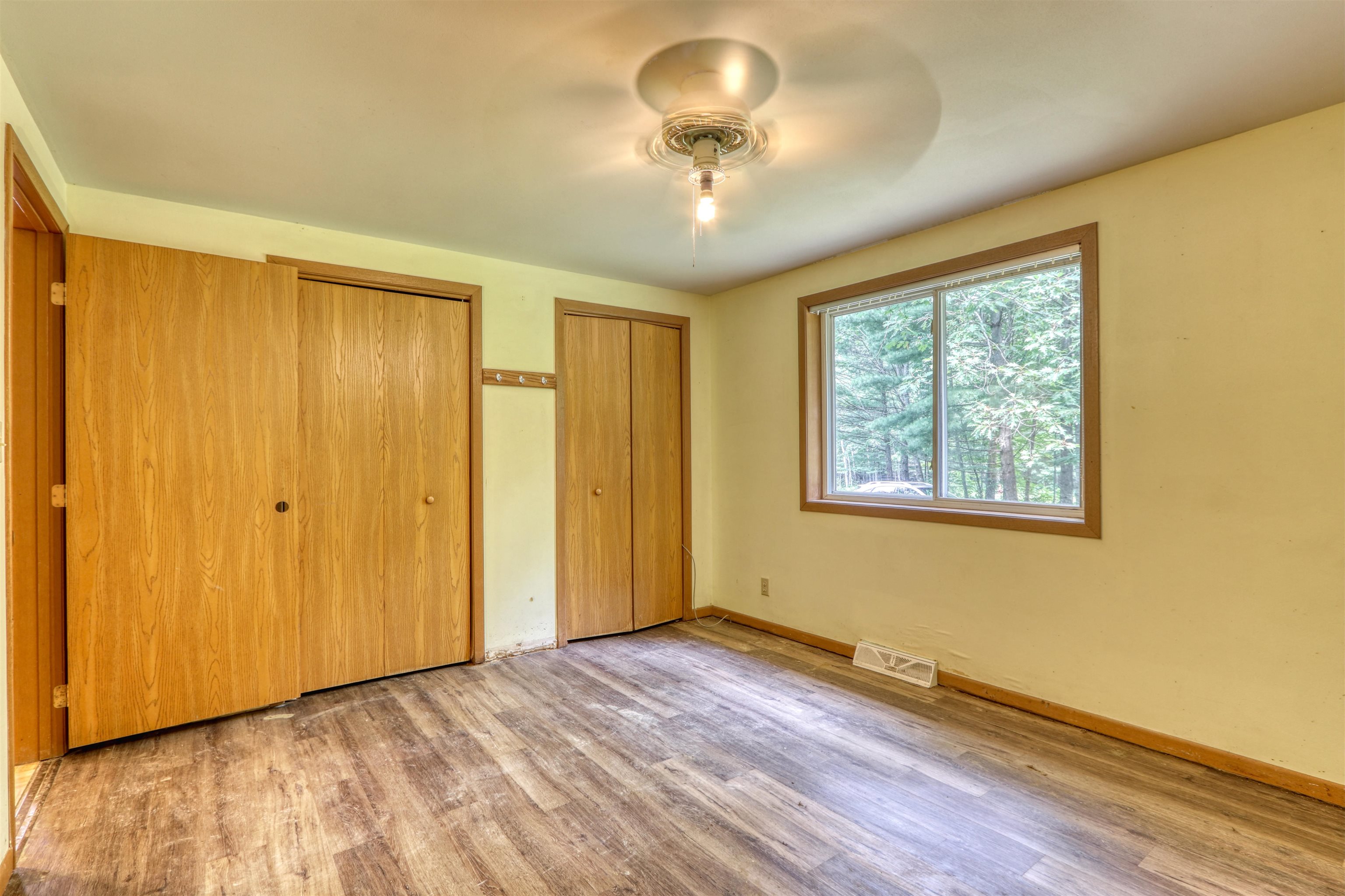 22655 Sunset Acres Lane Grand View, WI 54839 - Photo 19 of 47 Unfurnished bedroom with light wood finished floors, multiple closets, and ceiling fan