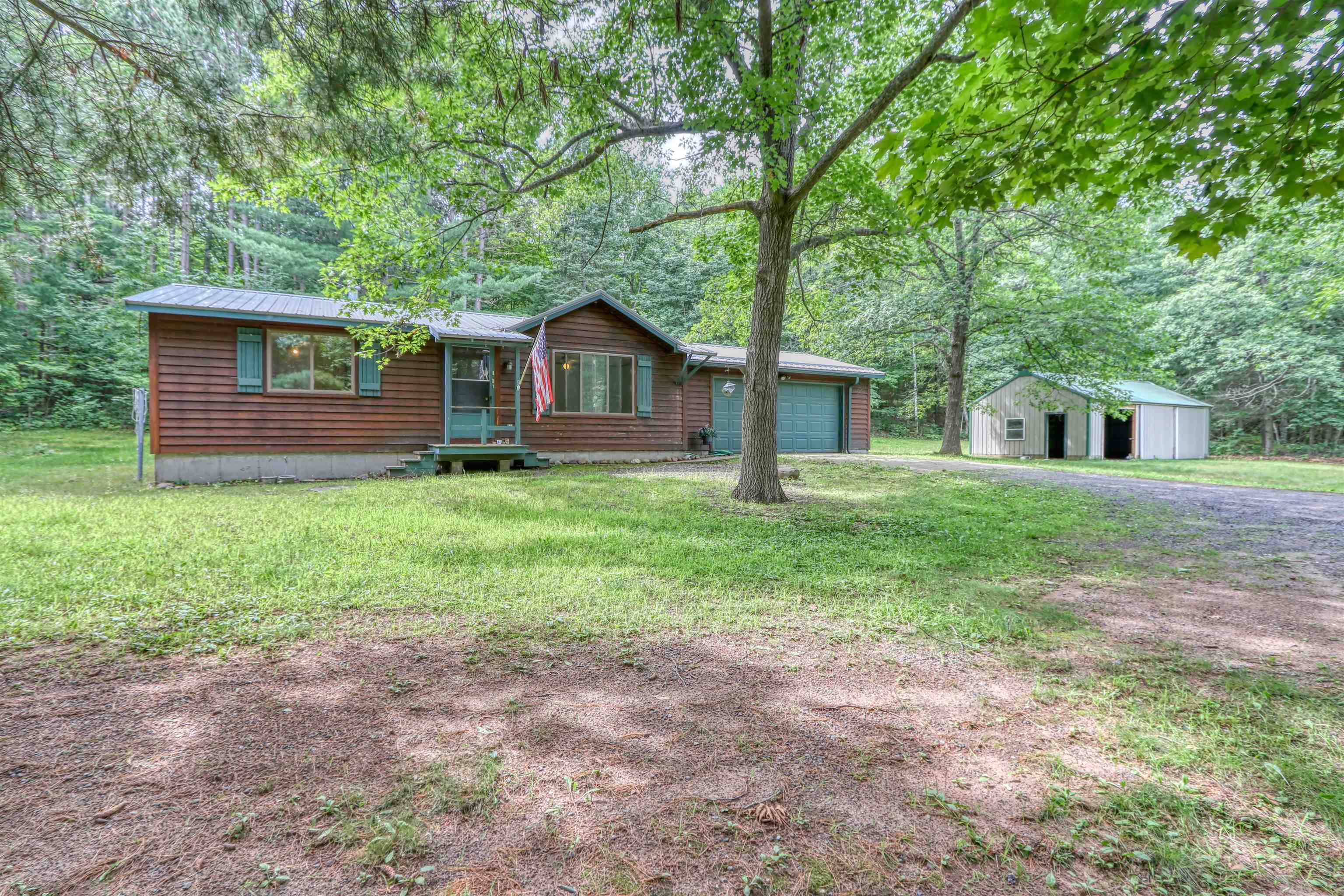 22655 Sunset Acres Lane Grand View, WI 54839 - Photo 2 of 47 View of front facade featuring a garage, a front yard, driveway, and a metal roof