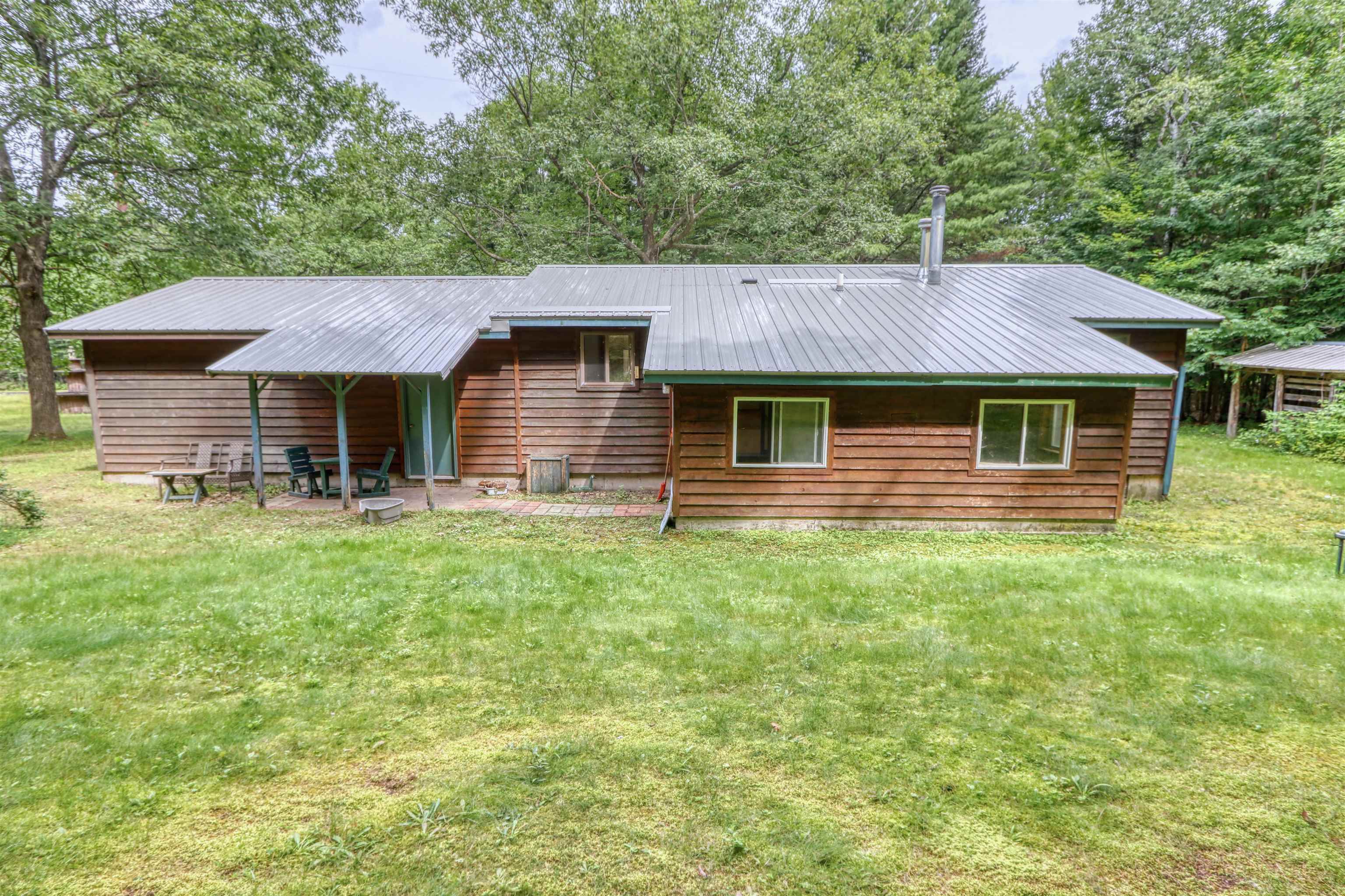 22655 Sunset Acres Lane Grand View, WI 54839 - Photo 43 of 47 Rear view of property with a metal roof, a patio area, a yard, and view of scattered trees