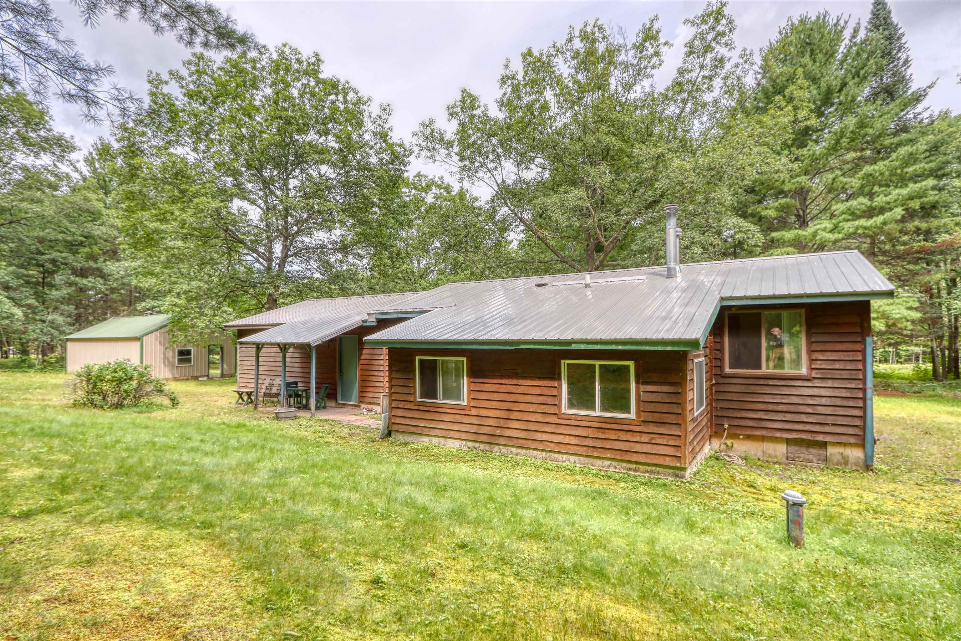 22655 Sunset Acres Lane Grand View, WI 54839 - Photo 7 of 47 Rear view of house with a metal roof, a lawn, view of scattered trees, and an outdoor structure