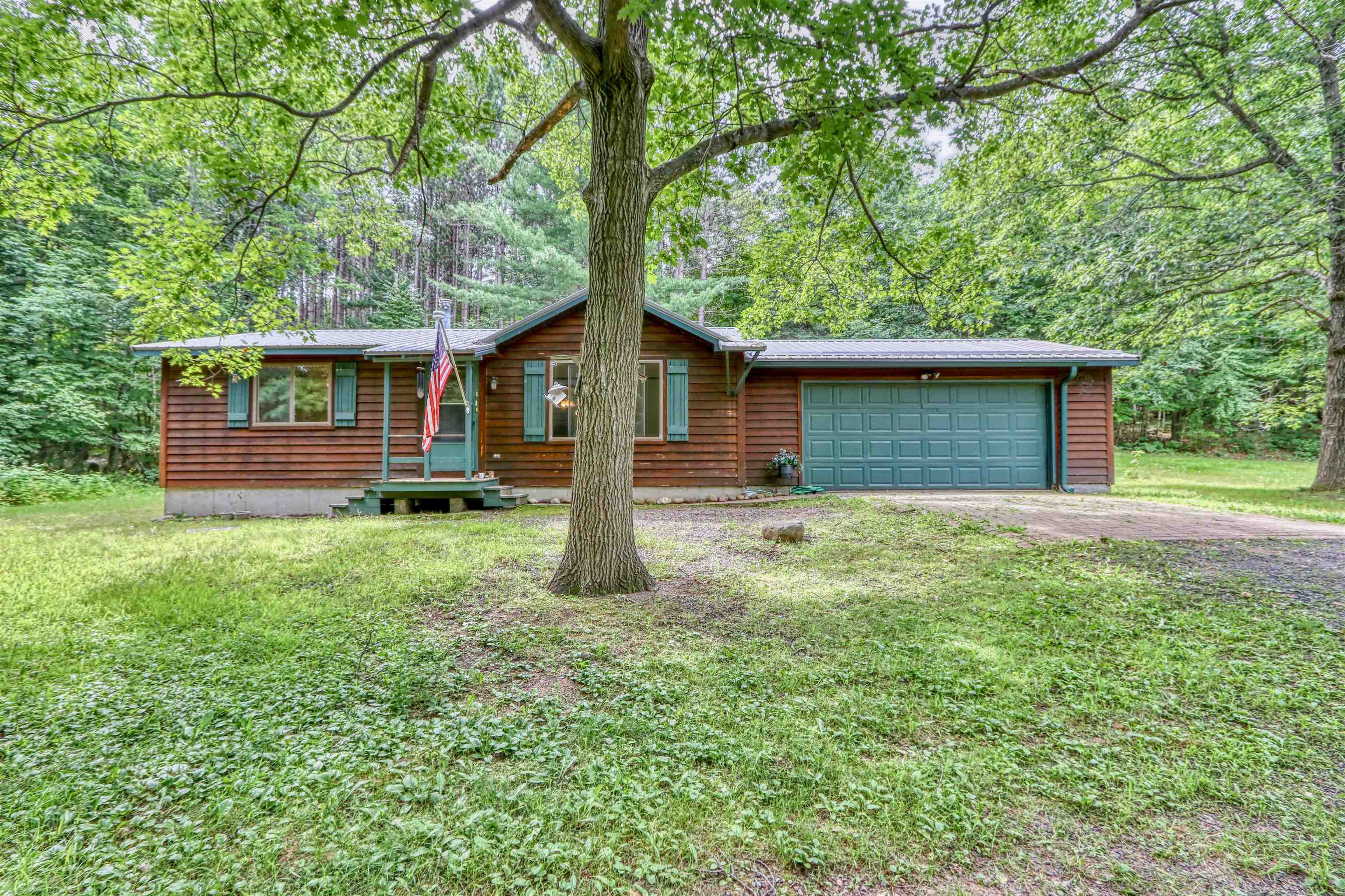 22655 Sunset Acres Lane Grand View, WI 54839 - Photo 9 of 47 Rustic home featuring driveway, a front yard, and a garage