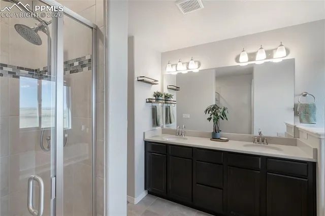 a bathroom with a double vanity sink mirror and shower