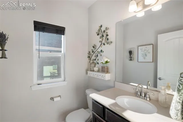 a bathroom with a granite countertop sink toilet and mirror