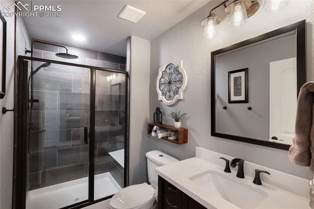 a bathroom with a sink vanity mirror and toilet