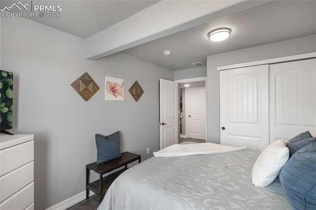 a bedroom with a bed and a painting on the wall