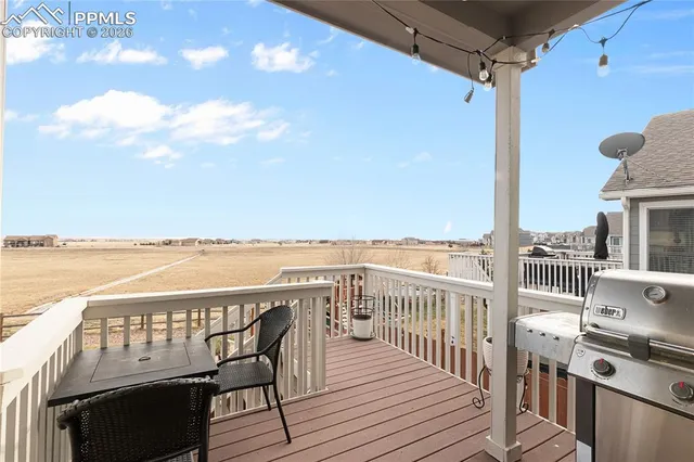 a view of a balcony with wooden floor & fence