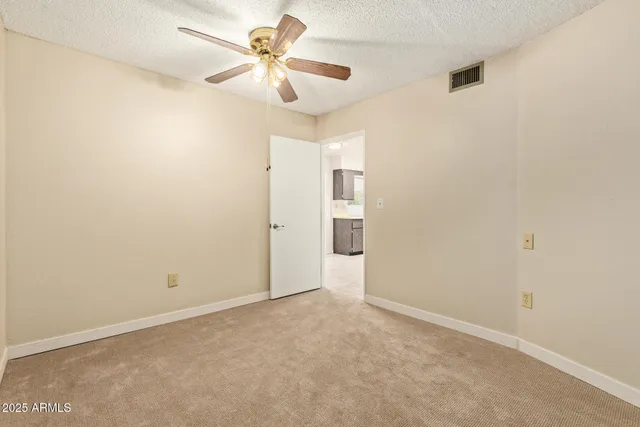 an empty room with a chandelier fan