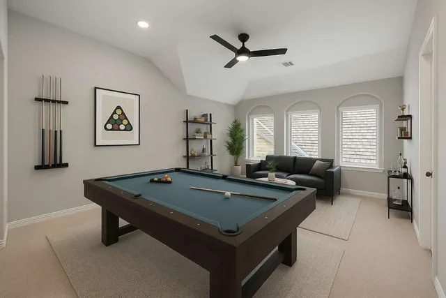 a living room with pool table and windows