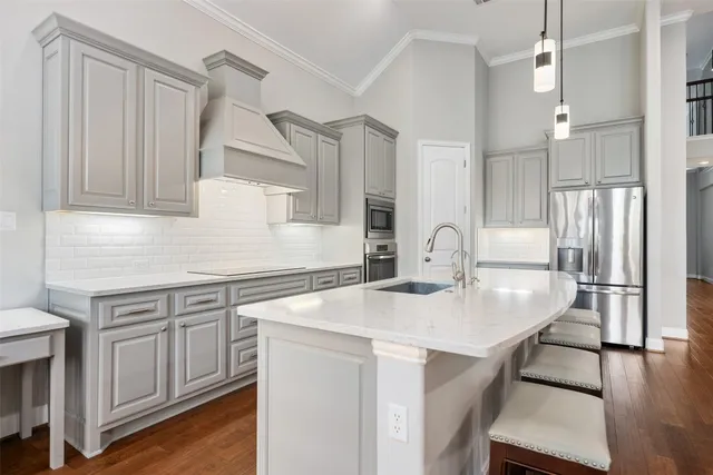 a kitchen with stainless steel appliances a dining table chairs and wooden floor