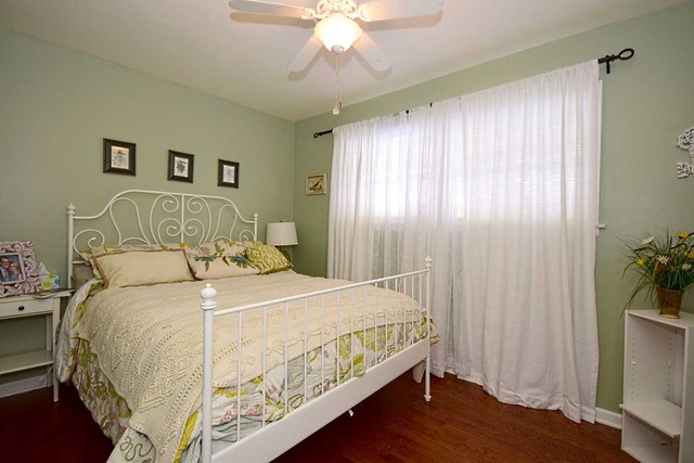 1219 Good Avenue Park Ridge, IL 60068 - Photo 9 of 25 a bedroom with a large bed and a chandelier