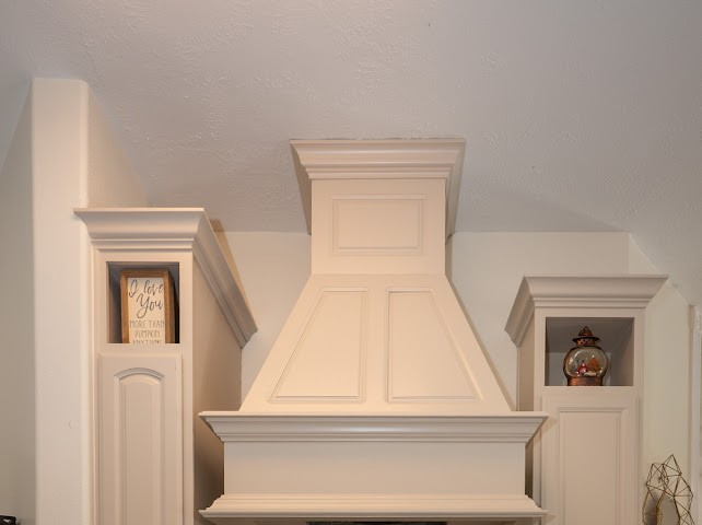 1114 Wagon Road Simonton, TX 77485 - Photo 27 of 48 Elegant built-in cabinetry with a stylish range hood adds charm and functionality to the kitchen space.