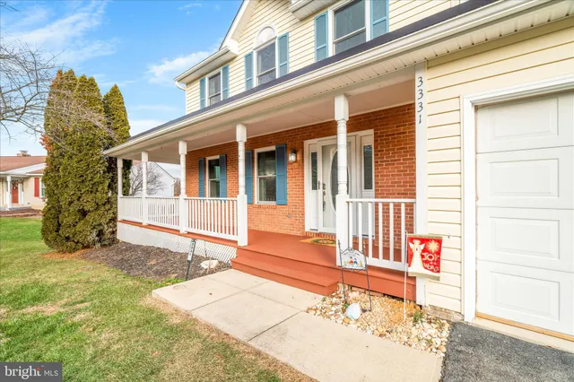 a view of a hallway with wooden floor and a bathroom