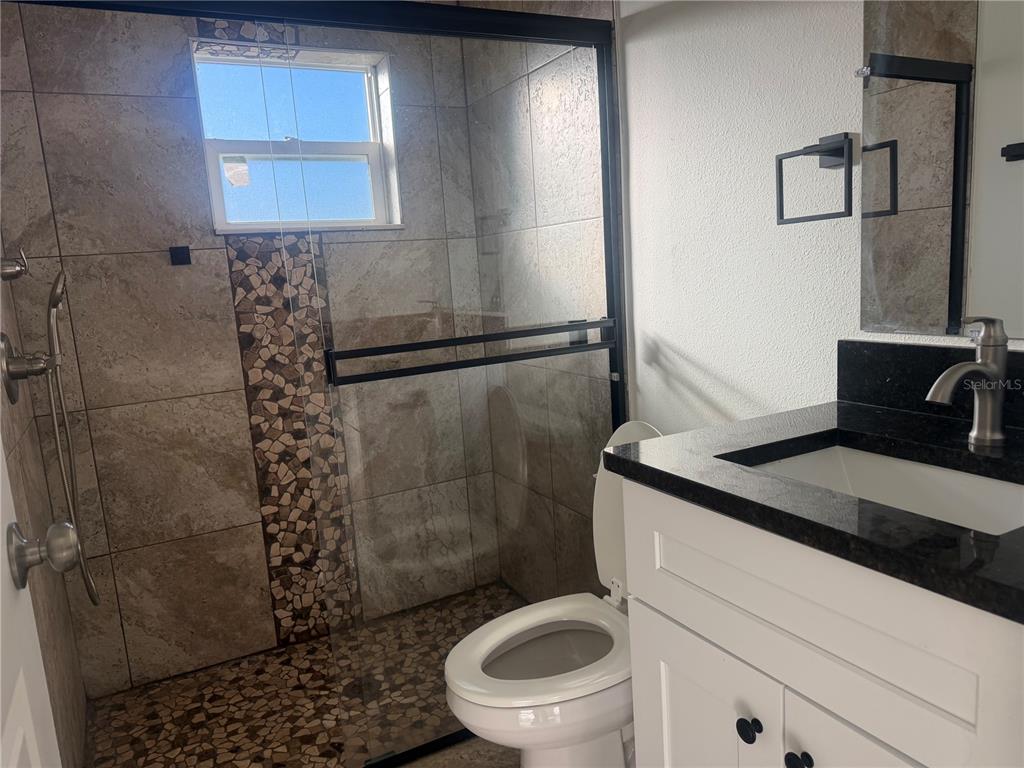 3444 Packard Avenue St. Cloud, FL 34772 - Photo 20 of 28 a bathroom with a granite countertop sink toilet and shower
