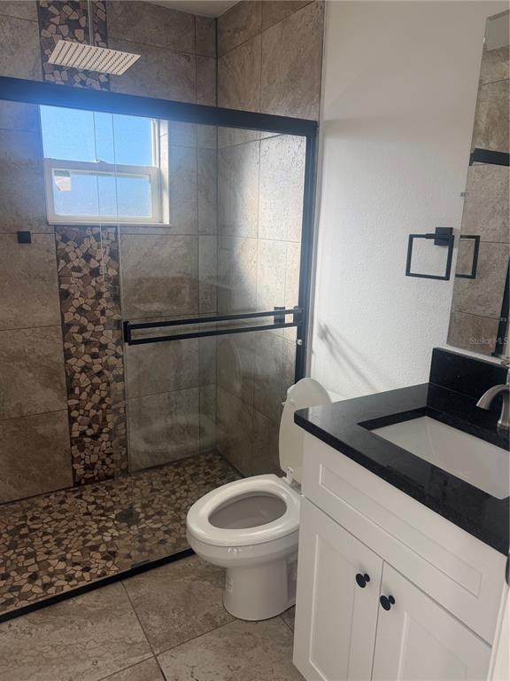 3444 Packard Avenue St. Cloud, FL 34772 - Photo 9 of 28 a bathroom with a granite countertop sink a toilet a mirror and shower