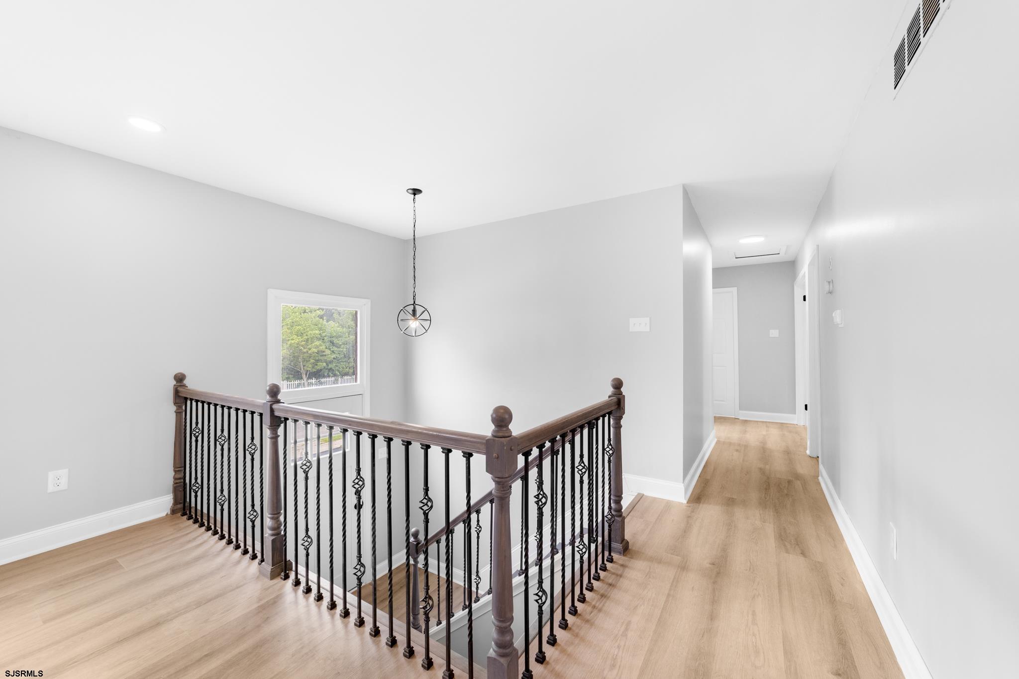 243 Wintergreen Lane Penns Grove, NJ 08069 - Photo 14 of 32 a view of a hallway with wooden floor and a chandelier