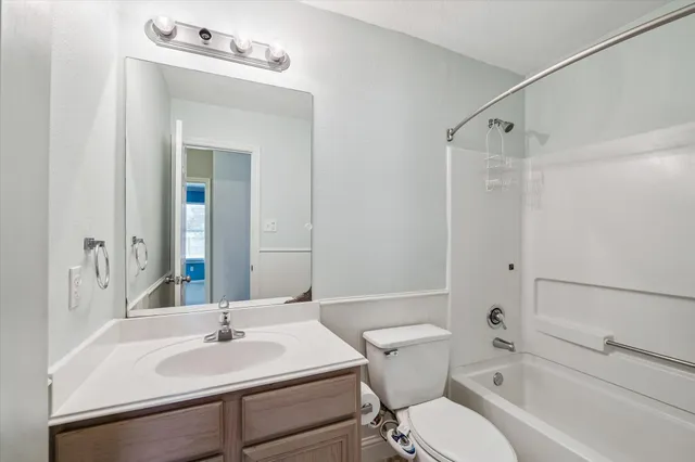 a bathroom with a sink vanity mirror and toilet