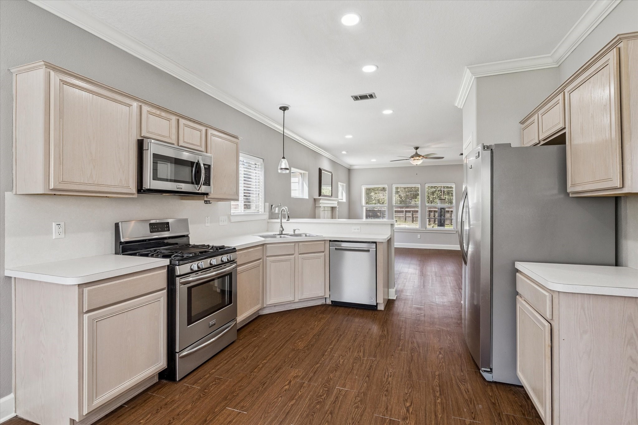 8 Pineway Conroe, TX 77304 - Photo 3 of 20 a kitchen with stainless steel appliances granite countertop a stove top oven a sink dishwasher and a refrigerator with wooden floor