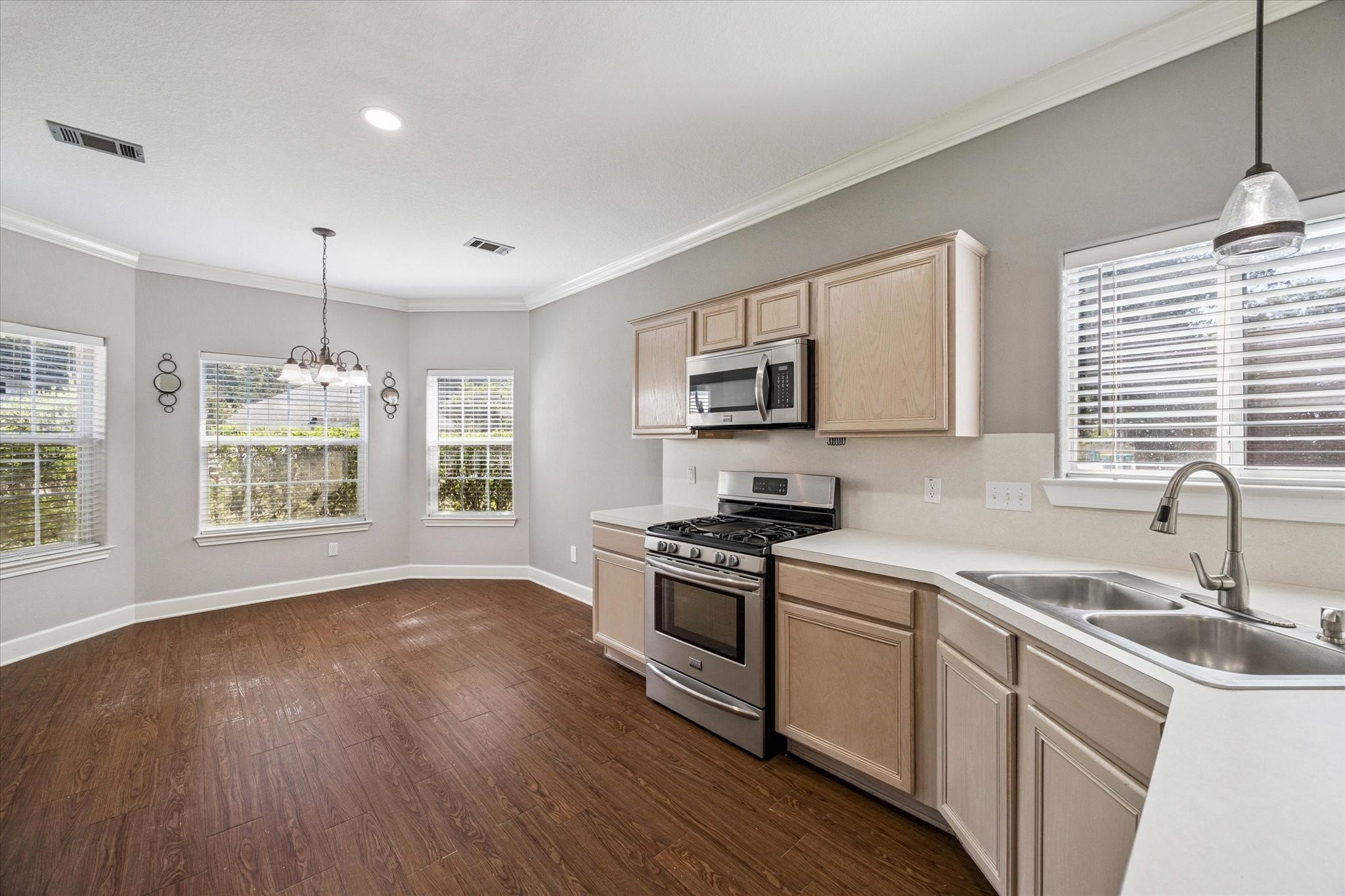 8 Pineway Conroe, TX 77304 - Photo 4 of 20 a kitchen with stainless steel appliances granite countertop a sink a stove a microwave a refrigerator a window and cabinets