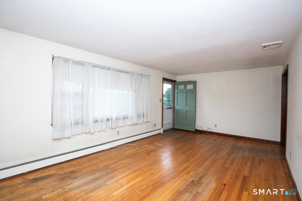 64 Somer Drive Meriden, CT 06451 - Photo 8 of 28 an empty room with wooden floor and windows
