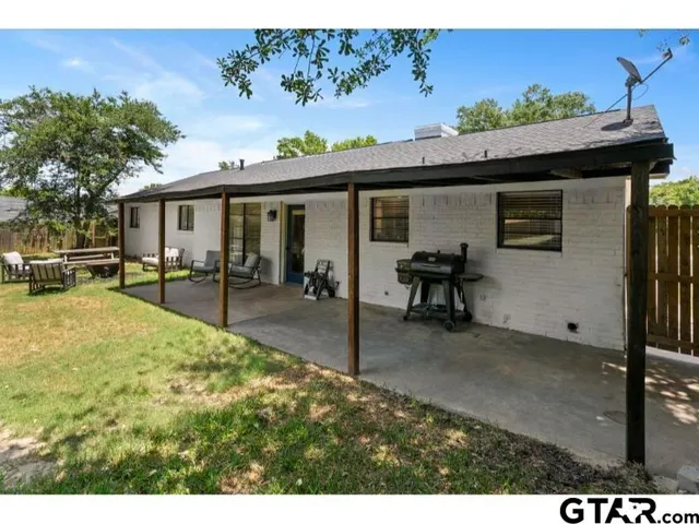 a view of a porch with furniture and a yard