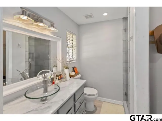 a bathroom with a sink a toilet and shower