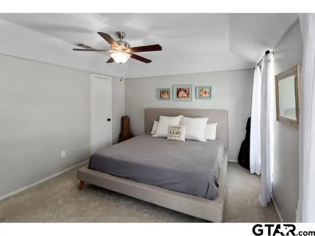 a bedroom with a bed and a ceiling fan