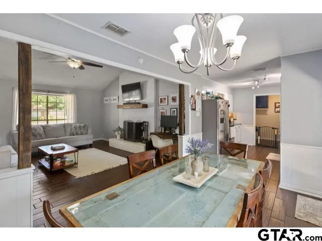 a living room with furniture a chandelier and a dining table